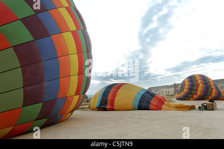 preparing hot air balloons for flying at dawn, colorful vista, panoramic against early morning clouds, horizontal scene Stock Photo