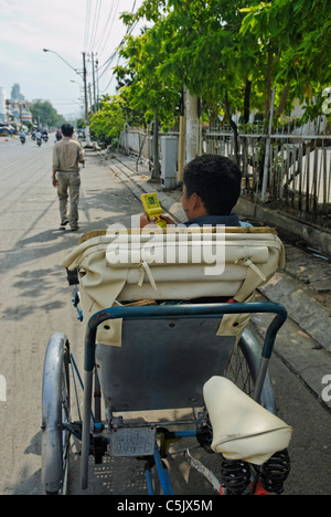 Asia, Vietnam, Nha Trang. Cyclo (cycle rickshaw) driver waiting for customers. Stock Photo