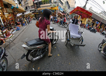 Asia, Vietnam, Hanoi. Hanoi old quarter. Elegant vietnamese woman on motorbike. Stock Photo