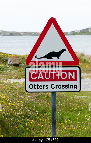 A roadsign warns motorists of Otters Crossing a road in the Outer Hebrides. Stock Photo