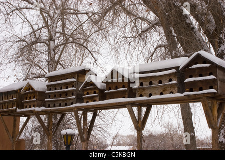 Snow-covered birdhouses in Taos County Stock Photo