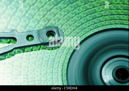 moving hard drive head with green data on drive Stock Photo