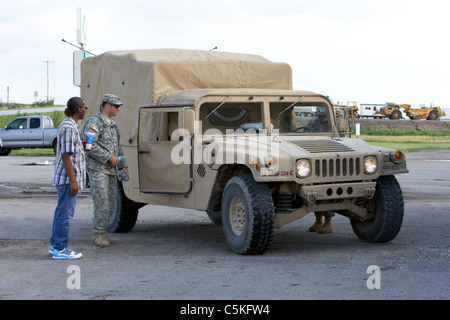 local man talks to Iowa army national guard soldiers at humvee united states military in front of levees at the missouri river Stock Photo