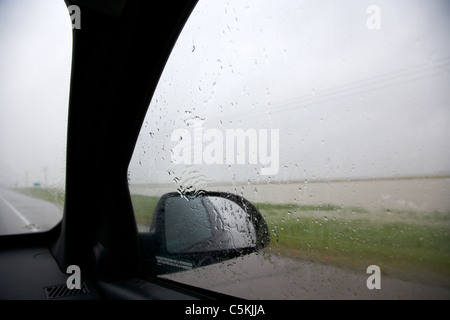 looking out of car driving through heavy rainstorm and flooding in southern saskatchewan canada Stock Photo