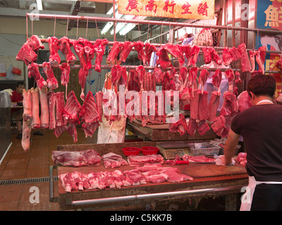 Chinese butcher at work preparing meat for sale at a market in Hong ...