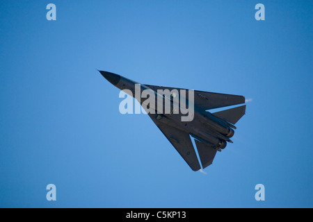 General Dynamics F-111 jet fighter aircraft of Royal Australian Air Force from below, flying at speed with wings swept back and Stock Photo