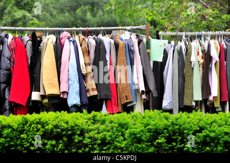 Large number of clothes hanging outside for sale in New York City. Stock Photo