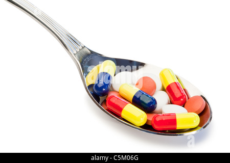 Spoon full of different kinds of pills Stock Photo