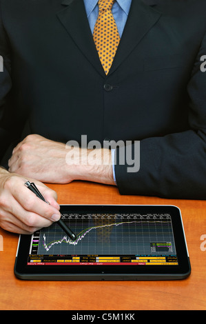 Businessman Using a Digital Tablet Computer to Check Stock Market Prices Stock Photo