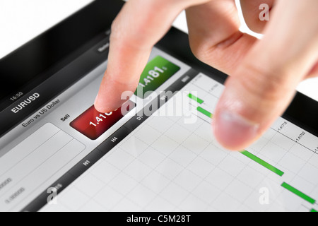 Touching sell button on stock market EUR/USD pair on a touch screen device. Stock Photo