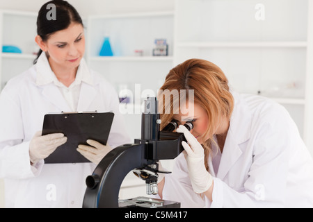 Blond scientist and her assistant conducting an experiment Stock Photo