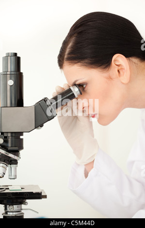 Female scientist looking through a microscope Stock Photo