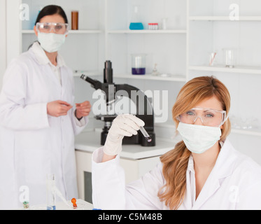 Blonde and dark-haired scientists posing in lab Stock Photo
