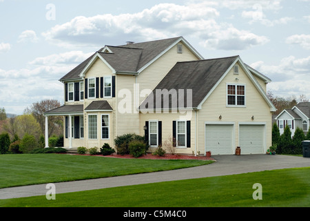 A modern colonial style residential suburban home with a small porch and a two car garage. Stock Photo