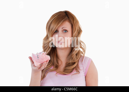 Blond-haired woman sad with her broken piggybank Stock Photo