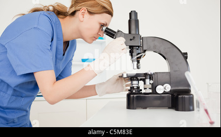 Female scientist looking through a microscope Stock Photo