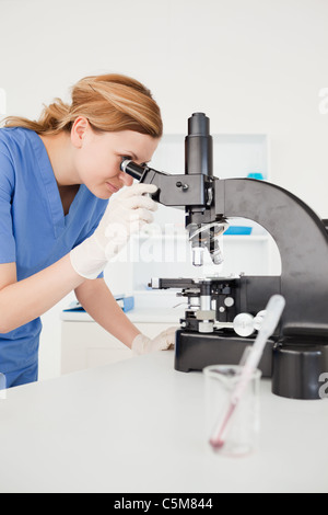 Cute female scientist looking through a microscope Stock Photo
