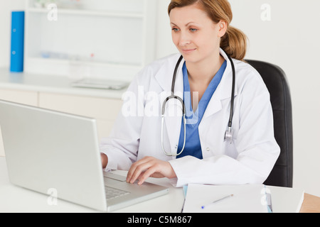 Attractive female doctor working on her laptop Stock Photo
