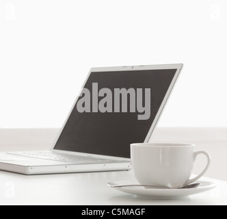 Modern laptop and cup of tea on a table Stock Photo
