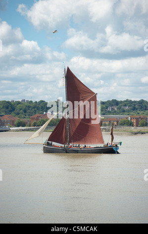 Traditional Thames sailing barge travelling downstream along the River Thames at Dagenham, Essex. Stock Photo