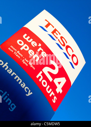 Sign outside Tesco supermarket open 24 hours a day in Hackney London UK Stock Photo