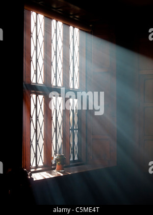 Bright sunlight streaming through a window with shafts of light visible Stock Photo