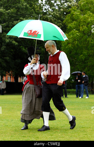 Dancers in traditional dress dancing under umbrella on Midsummers Day, Cathays Park, Cardiff, South Glamorgan, Wales, UK Stock Photo