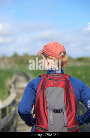 Woman hiking on a marsh boardwalk.  Grassy Narrows Marsh, Manitoba, Canada. Stock Photo