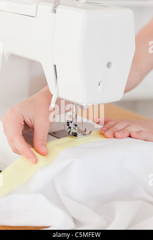 Caucasian hands using a sewing machine Stock Photo