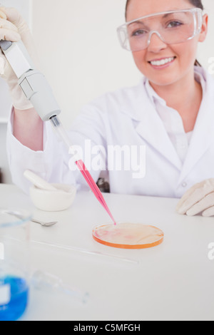 Attractive red-haired scientist using a pipette Stock Photo