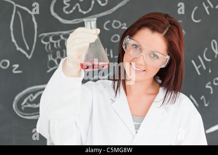 Close up of a cute scientist showing a conical flask Stock Photo
