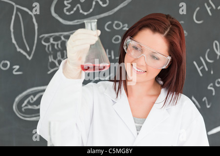 Close up of a cute scientist looking at a conical flask Stock Photo