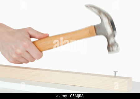 Hand holding a hammer to drive a nail Stock Photo