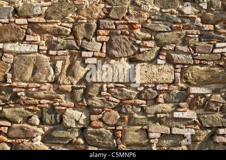 Old stone wall with some bricks in Portugal Stock Photo