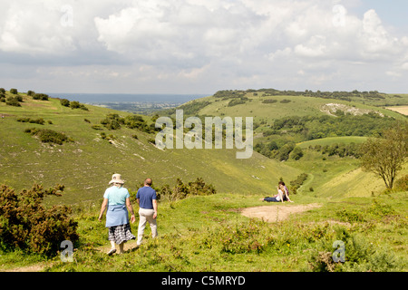 A couple walking at Devils Dyke near Brighton in the South Downs National Park approach a young couple enjoying the view Stock Photo