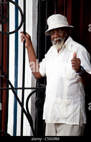 An elderly man standing outside a Cuban cigar factory smoking a Cuban cigar Havana Habana Cuba Stock Photo