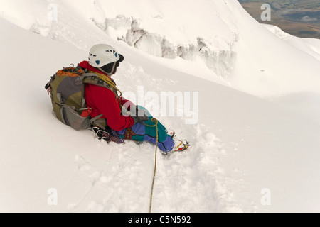 Cotopaxi volcano in Ecuador Andes, climber taking a break high on the slopes of the volcano and taking in the view Stock Photo