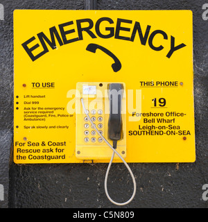 Wall mounted outdoor seaside emergency SOS telephone at Bell Wharf beside Thames Estuary Old Leigh on Sea Essex England UK district of Southend on Sea Stock Photo