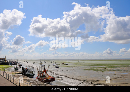 Thames Estuary low tide landscape boats & mud flats at Leigh on Sea Essex Coast England UK with Kent coastline horizon distant with clouds in big sky Stock Photo