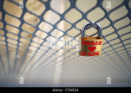 Padlocks expressing couple's love for one another attached to fencing on a footbridge in Italy. Stock Photo
