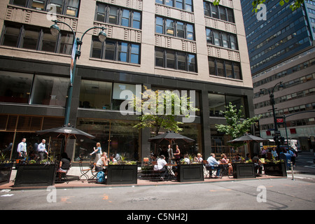 Lunching office workers take advantage of a pop-up seating 'cafe' in Midtown Manhattan in New York Stock Photo