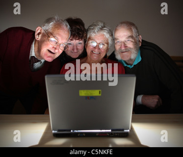 Older people looking at the screen and enjoying using a modern laptop computer Stock Photo