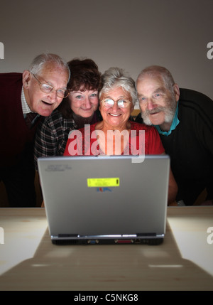Older people looking at the screen and enjoying using a modern laptop computer Stock Photo