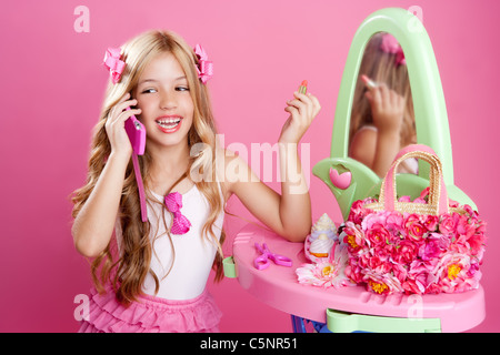 Children fashion doll blond girl talking mobile phone in pink vanity Stock Photo