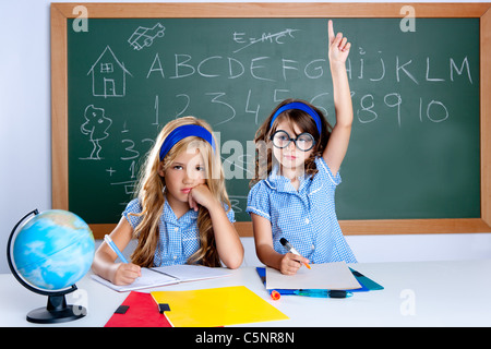 clever nerd student girl in classroom raising hand with sad friend Stock Photo