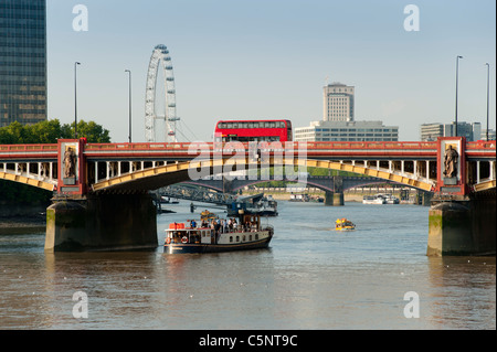 Vauxhall Bridge spanning the River Thames in London, England, UK. Showing the London Eye, a London bus and various boats. Stock Photo