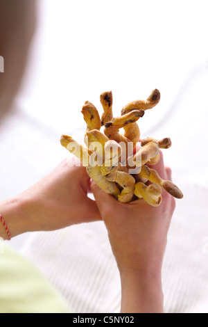 Woman holding a grissini (bread sticks) with black olives Stock Photo