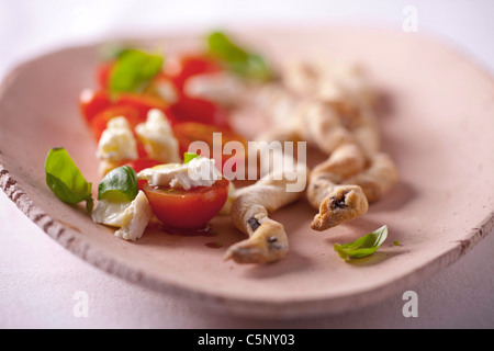 Grissini (bread sticks) with black olives, served with coctail tomatoes and brie cheese Stock Photo