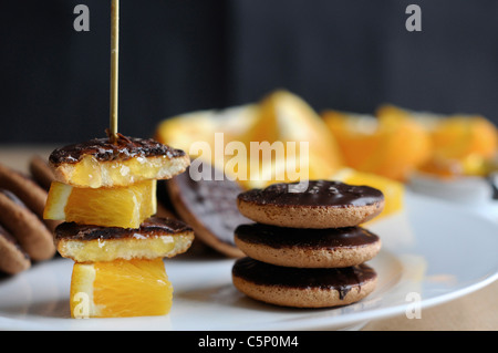 Orange chocolate cookies with orange segments on a skewer (Jaffa cakes) Stock Photo