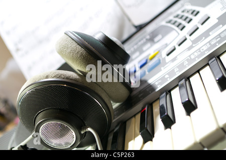 Headphones lying on a digital piano Stock Photo